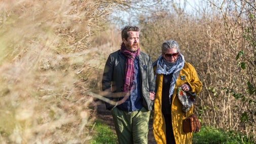 Couple walking along a woodland path at Speke Hall, Liverpool